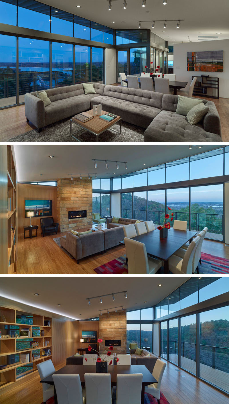 A wall of glass with access to the balcony allows for a picturesque view from the living and dining area of this home, as well as the kitchen. In the living room, the couch is focused on the stone fireplace hearth. Sharing the space is also the dining room, positioned between the living room and the kitchen.