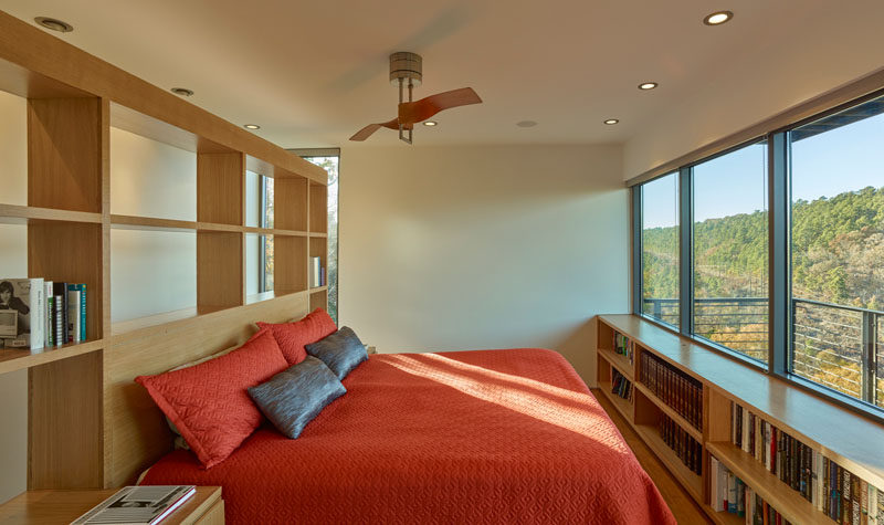 This master bedroom has custom woodworking with plenty of shelving, and the bed positioned to take advantage of the views.