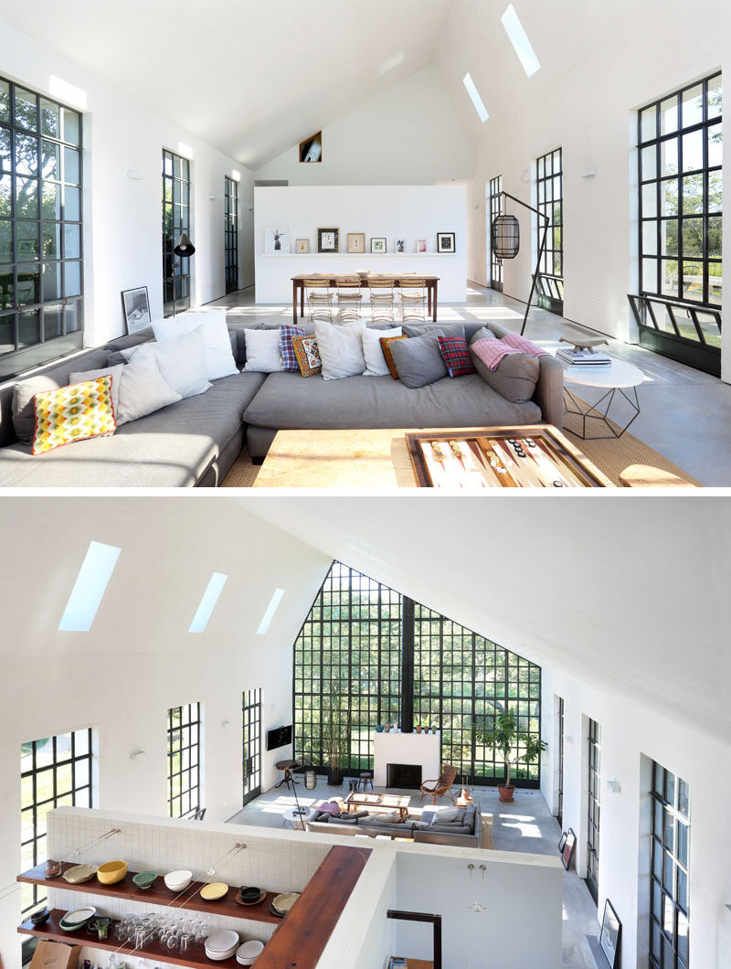 The living room of this guest house is focused around the fireplace, while the dining area is positioned in line with one of the side windows. Behind the white partition wall, there's the kitchen and a bathroom.