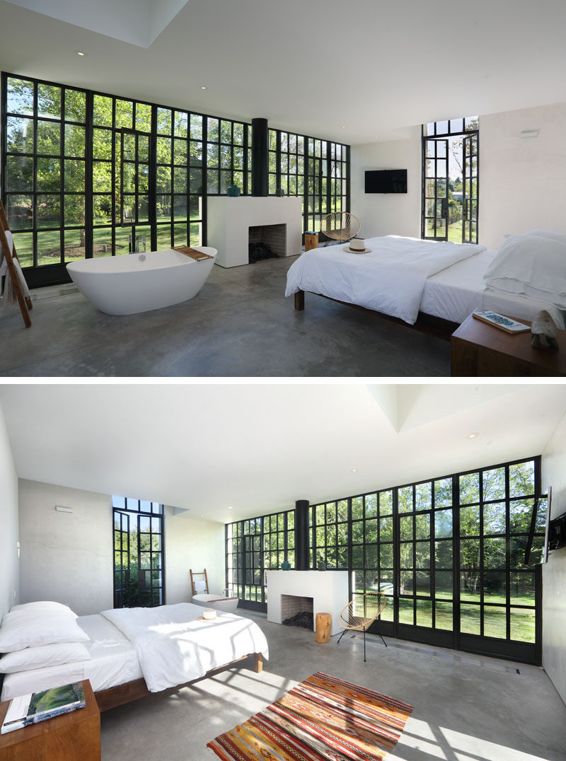 This bedroom with a standalone bathtub, takes full advantage of the view and fireplace. The black steel casement windows contrast with the radiant concrete floors and white walls.