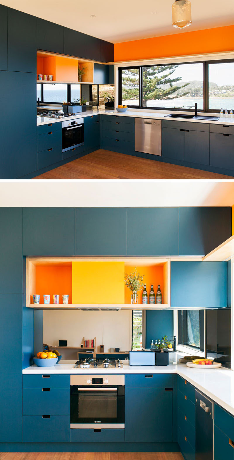 This dark blue kitchen is brightened up with white countertops and colorful pops of orange.