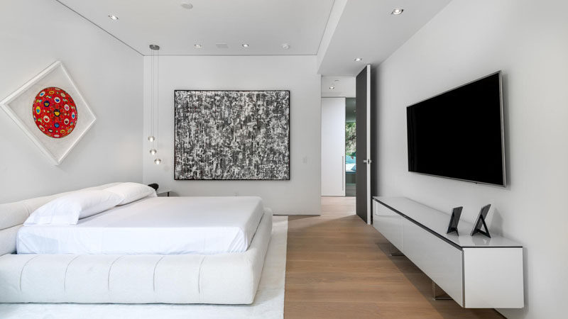 A simple black, white and wood color palette has been used in this bedroom, with a pop of red adding a touch of fun to the room.