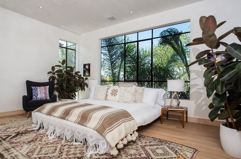 Lots of light enters this bedroom through the large black-framed windows.