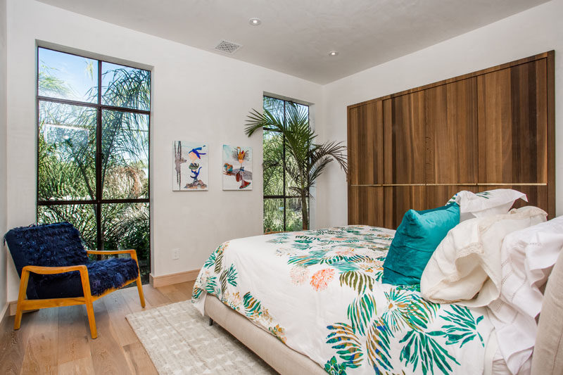 Lots of light enters this bedroom through the large black-framed windows.