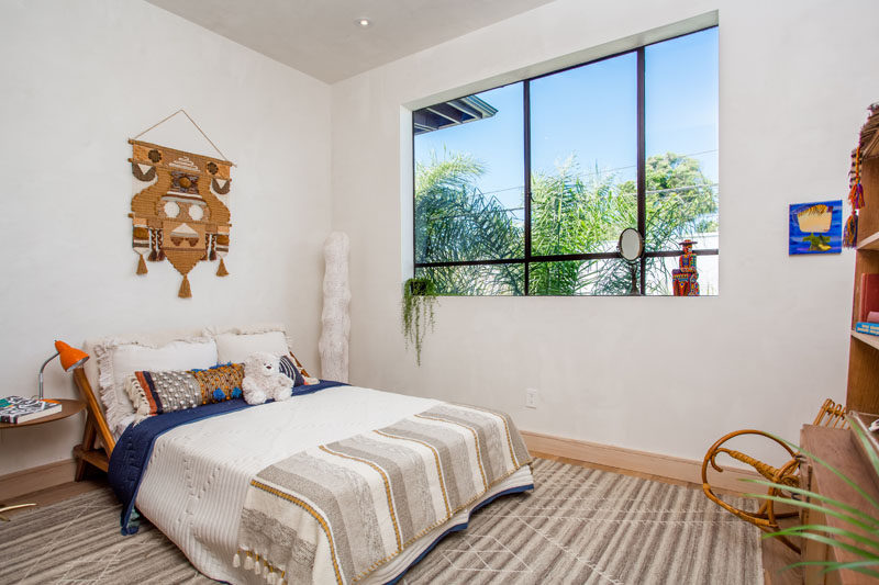 Lots of light enters this bedroom through the large black-framed windows.