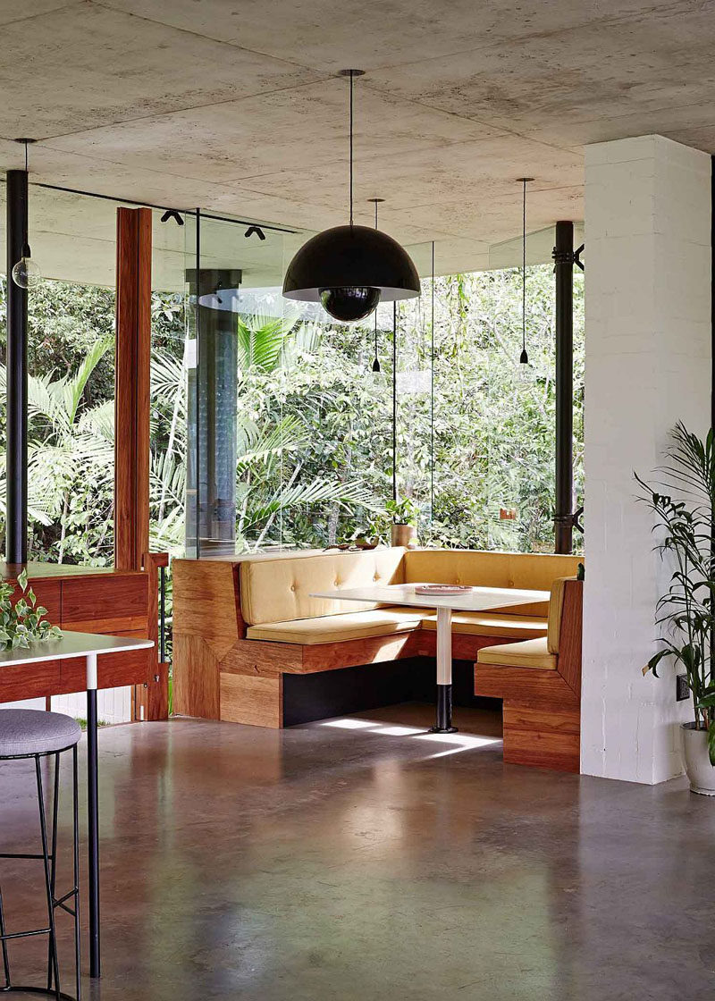 Dining Room Idea - Create A Built-In Dining Nook // Windows surrounding this built in dining area ensure that everyone at the table has incredible views of the rainforest outside. Upholstered cushions have been designed to match the dimensions of the benches. #DiningNook #BuiltInDiningNook #BanquetteSeating #DiningRoom