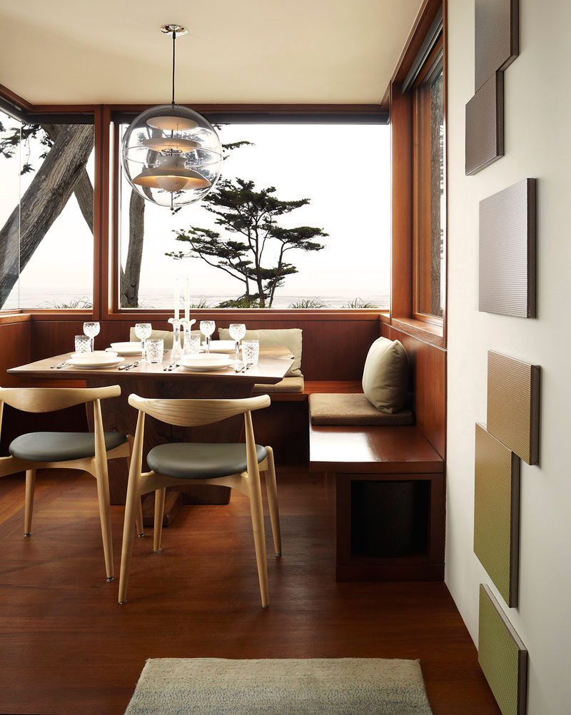 Dining Room Idea - Create A Built-In Dining Nook // The dark wood of the built-in seats is offset by the huge windows looking out over the ocean that brighten up the whole space. #DiningNook #BuiltInDiningNook #BanquetteSeating #DiningRoom