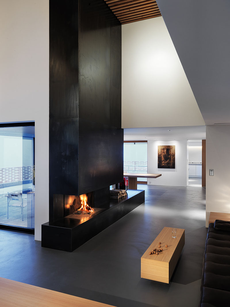 Fireplace Design Idea - 6 Different Materials To Use For A Fireplace Surround // This vertical black steel fireplace surround gives a modern, industrial feel to a room. #FireplaceSurround #FireplaceIdeas #SteelFireplaceSurround