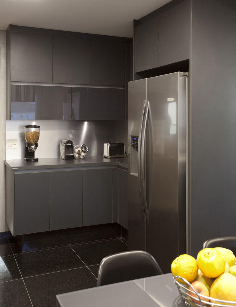 12 Examples Of Sophisticated Gray Kitchen Cabinets // Gray cabinets in both matte and glossy finishes add dimension and sophistication to this modern kitchen.