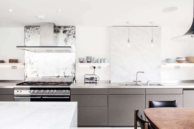 12 Examples Of Sophisticated Gray Kitchen Cabinets // The gray cabinets along the bottom half of the kitchen make it feel modern and new, while the vintage mirror behind the stove makes the space feel personalized and lived in.