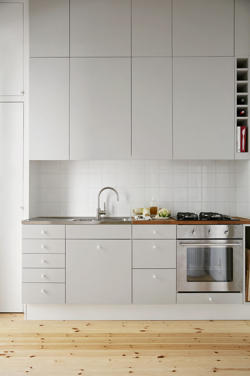 12 Examples Of Sophisticated Gray Kitchen Cabinets // Light gray cabinets above and below the work space, create a bright, warm atmosphere in this minimalist kitchen.