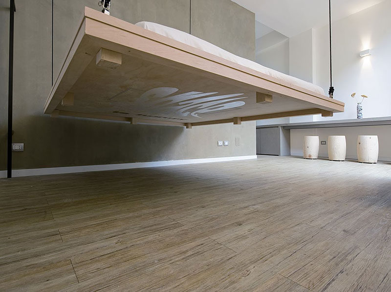 In this small apartment, the bed can be hoisted up to the ceiling to make way for a living area.