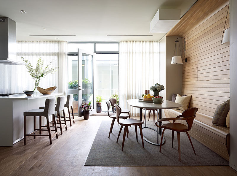 In this apartment, the television was placed behind a panel within the walnut wall, allowing it to be visible for when you want to watch tv, but at the same time, can be completely hidden away without the use of a bulky cabinet.