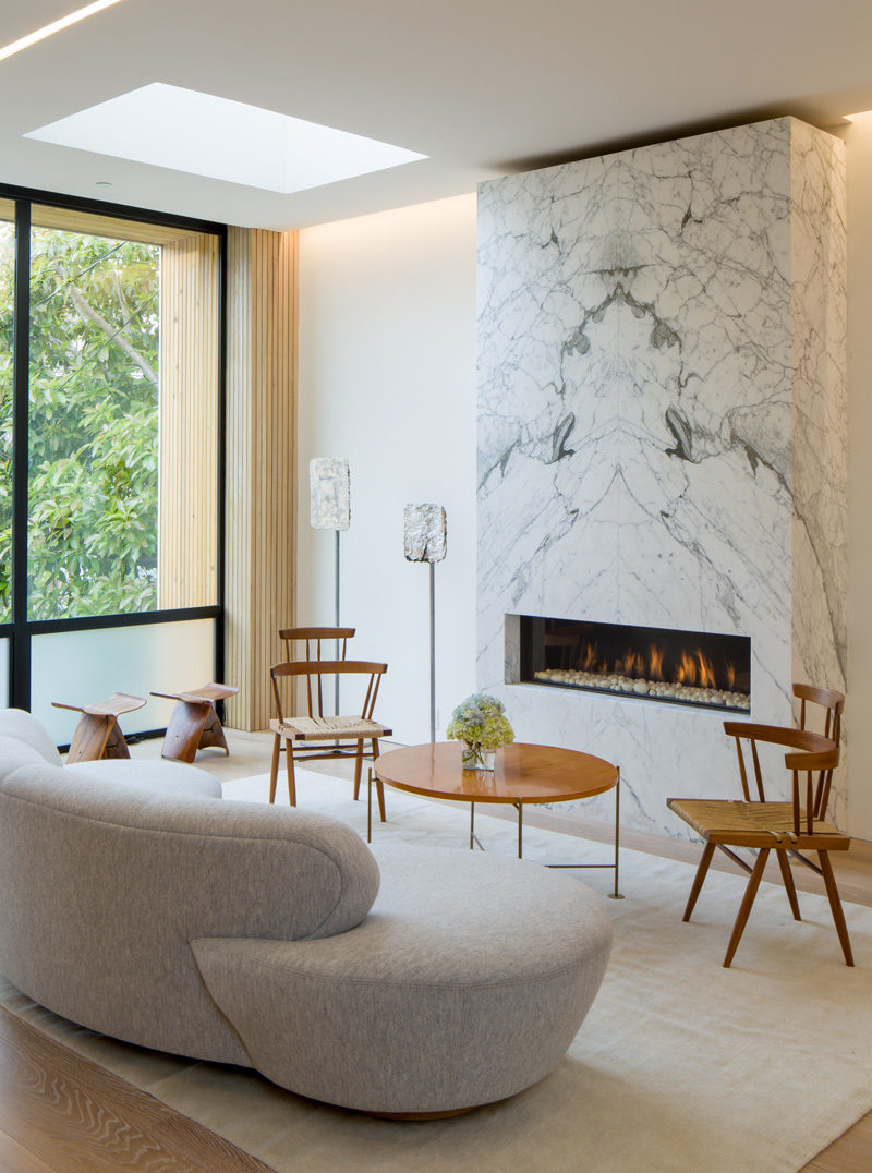 This living room features a fireplace with a stone surround, in a home in San Francisco.