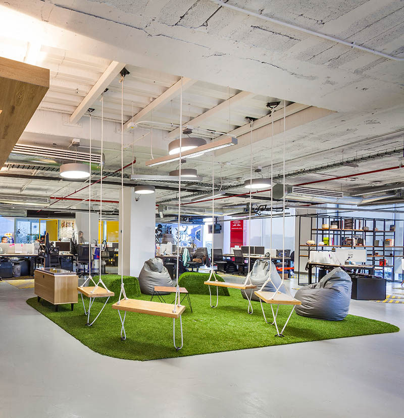 This Red Bull Office has a casual meeting area with a green rug and swings.