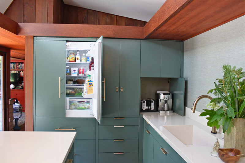 Kitchen Design Idea - 10 Inspirational Examples Of Kitchens With Integrated Fridges // The same calm blue green cabinets used throughout the kitchen also cover this fridge, helping it blend in and hiding it from view.