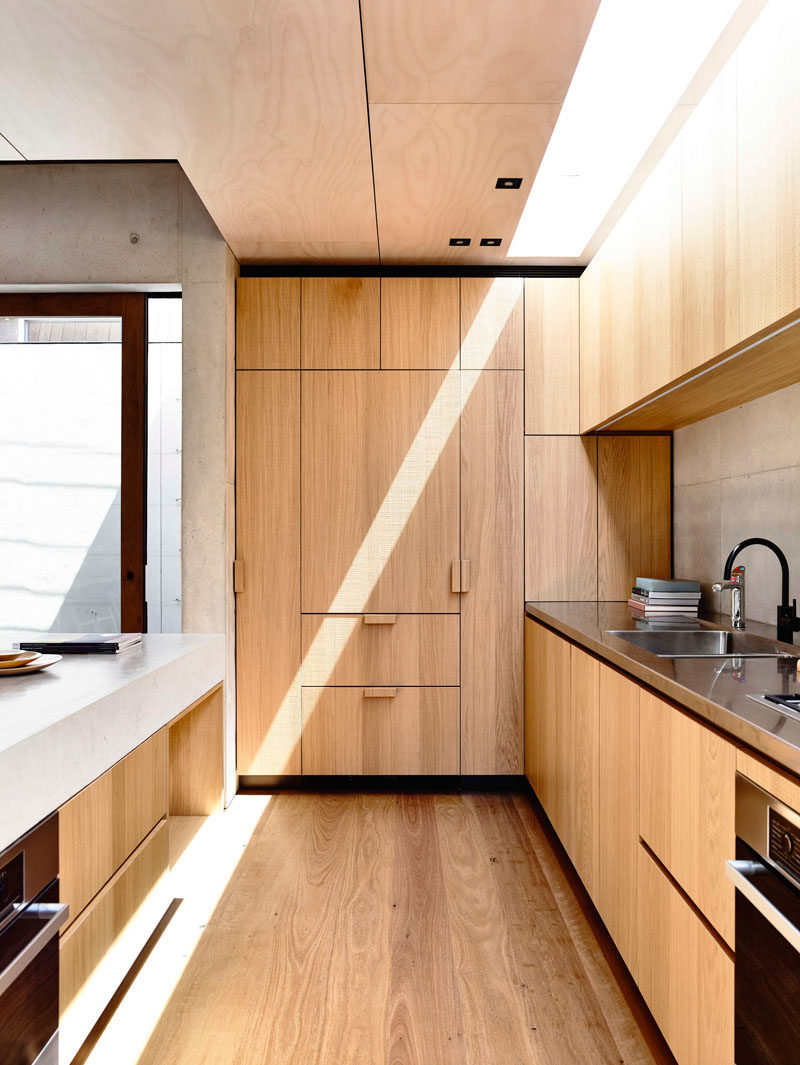 Kitchen Design Idea - 10 Inspirational Examples Of Kitchens With Integrated Fridges // Wooden cabinetry in this kitchen hides the the fridge and makes this kitchen feel more cohesive and unified.