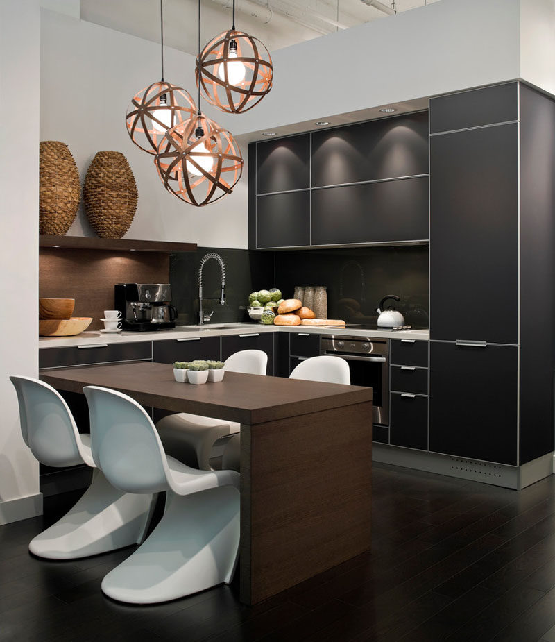 Kitchen Design Idea - 10 Inspirational Examples Of Kitchens With Integrated Fridges // The black cabinetry in this kitchen also covers the fridge and creates a sleek, modern looking kitchen.