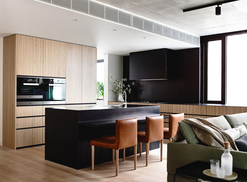 Kitchen Design Idea - 10 Inspirational Examples Of Kitchens With Integrated Fridges // The absence of a stand alone fridge makes this kitchen feel bigger and brighter, and lets the contrast between the black and the wood really stand out.