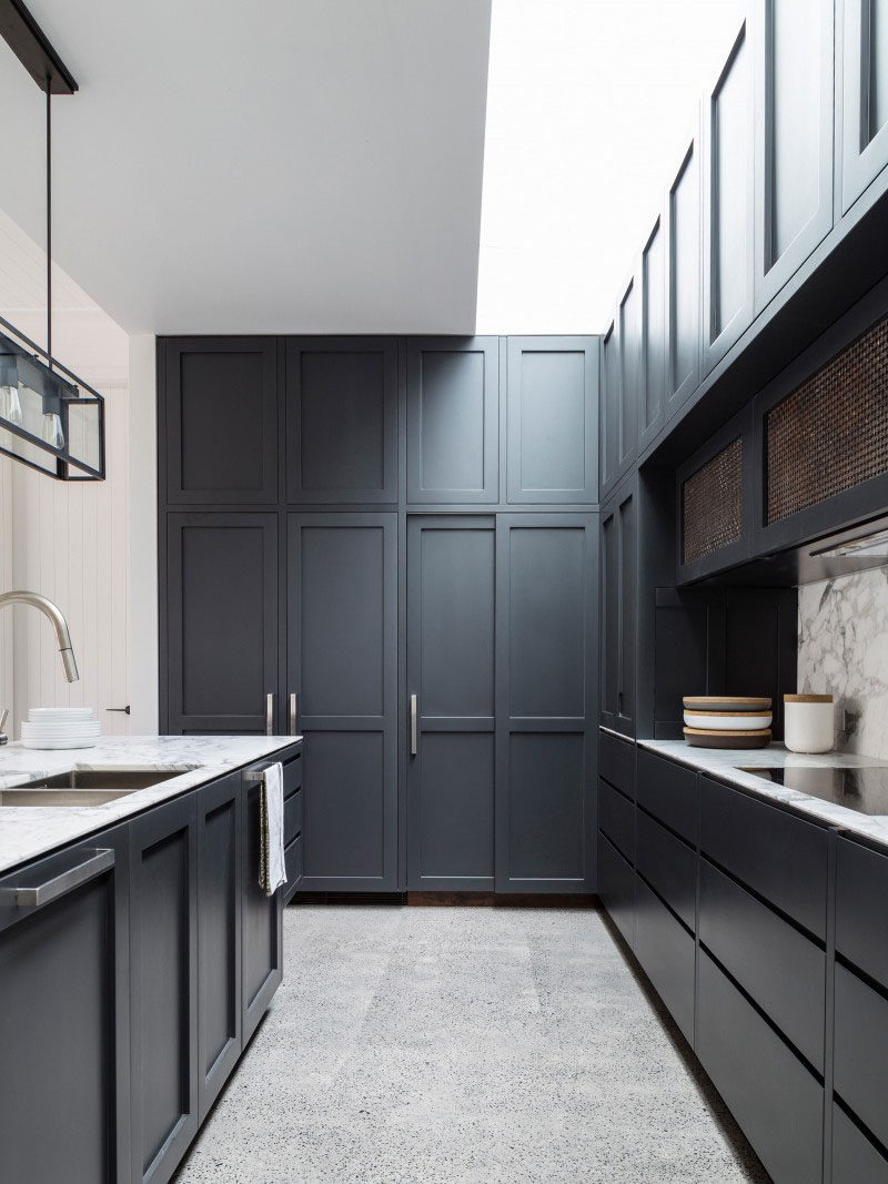 Kitchen Design Idea - 10 Inspirational Examples Of Kitchens With Integrated Fridges // A fridge is hidden behind these dark panels of this cabinetry of this kitchen.