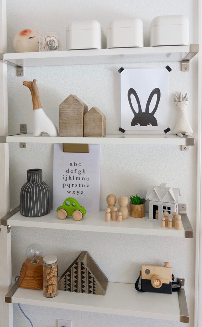 Personal mementos and minimalist toys on the shelves of this kids room add a sense of fun and whimsy to the room.