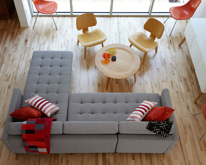 15 Living Room Layouts From Above // The use of light wood and grey help the red accents, like the chairs, pillows, and blanket really pop.