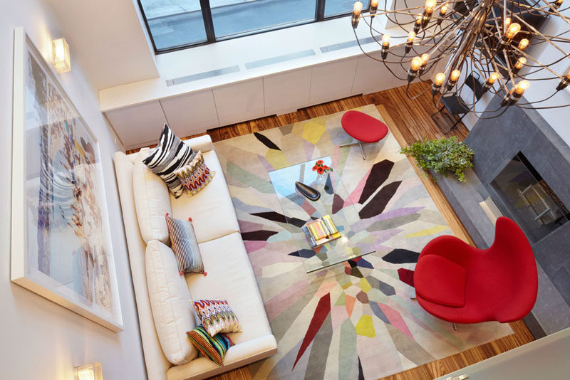 15 Living Room Layouts From Above // The bright rug, chair, and pillows are offset by the white walls and white couch, keeping the room fun rather than overwhelming.