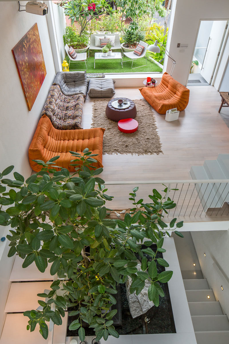 15 Living Room Layouts From Above // The painting on the wall ties all the colors in the living room together and makes the orange couches really blend in with the rest of the decor.