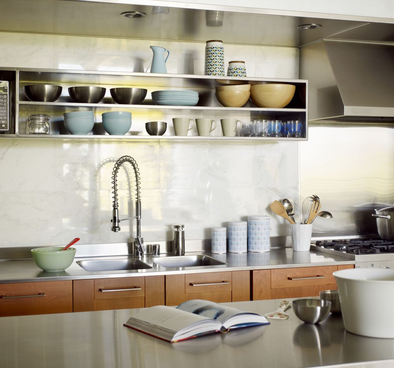 Kitchen Design Idea - Open Shelving (19 Photos) // The stainless steel shelves above the sink and work space of this kitchen make it feel industrial, but the earthy ceramics soften the overall feel and warm up the space.