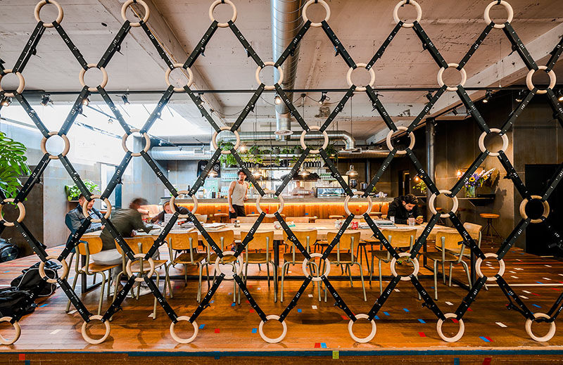 Room Divider Idea - The designers of this gym in Amsterdam made a room divider out of wooden gymnastic rings and straps, to separate the gym area from the bar/food area.