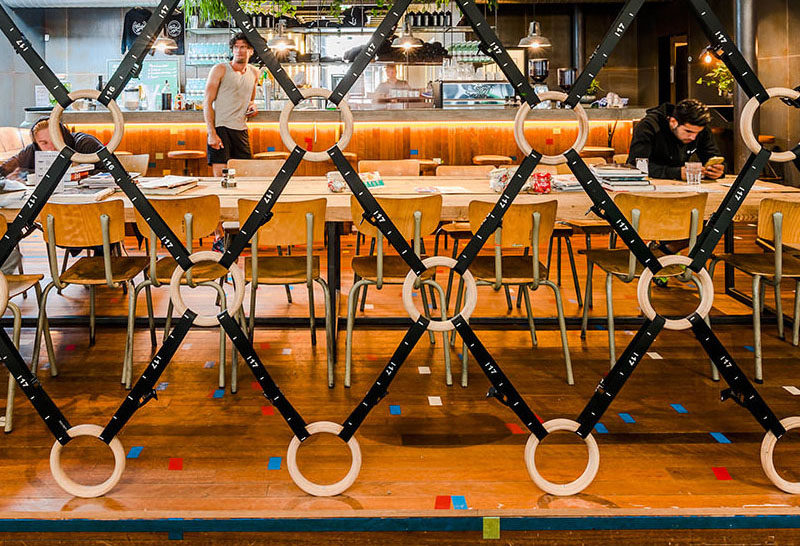 Room Divider Idea - The designers of this gym in Amsterdam made a room divider out of wooden gymnastic rings and straps, to separate the gym area from the bar/food area.