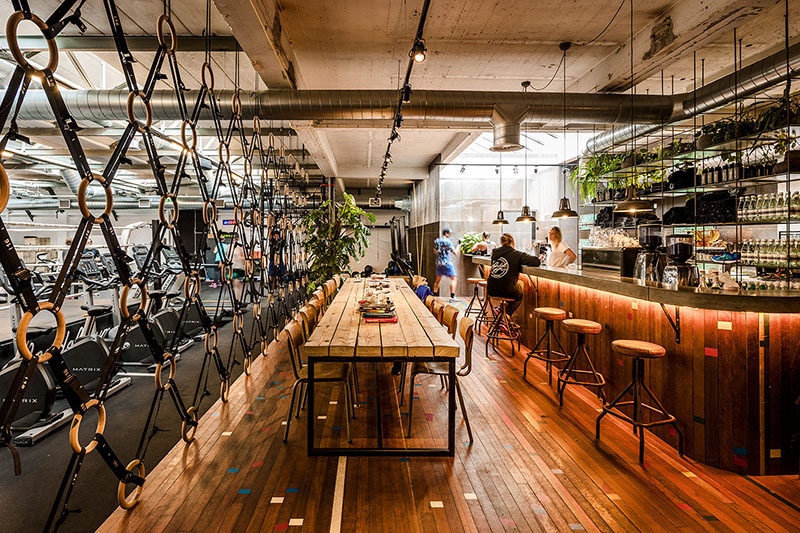 Room Divider Idea - The designers of this gym in Amsterdam made a room divider out of wooden gymnastic rings and straps, to separate the gym area from the bar/food area.