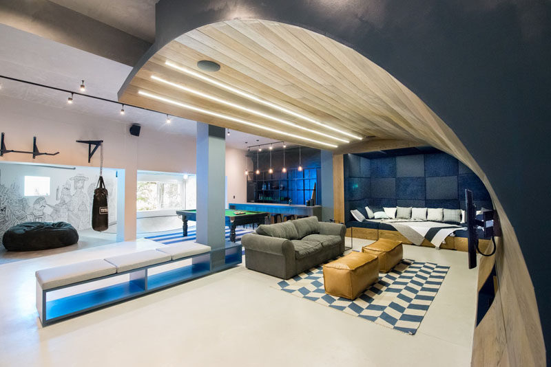 This basement designed for a teenager features a wooden wave, a bar/snack area, a skate bowl, arcade games and a workout area.