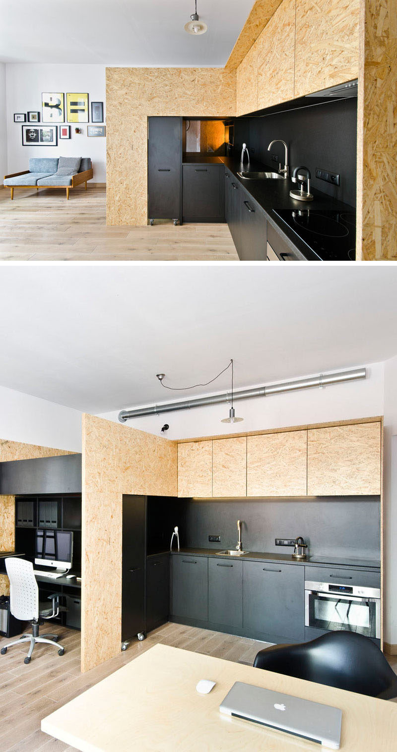 This matte black kitchen is part of a small apartment designed as a live/work space for a design studio.