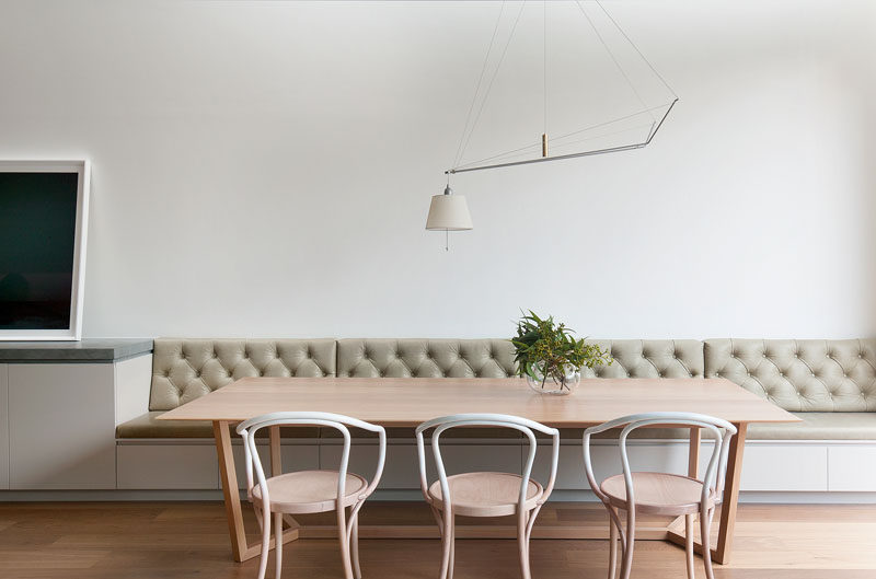 Dining Room Design Ideas - Use Built-In Banquette Seating To Save Space // White walls and lots of natural light help brighten this built-in tufted banquette seating, while a unique light fixture hangs above for extra light on dark days and to brighten evening meals.