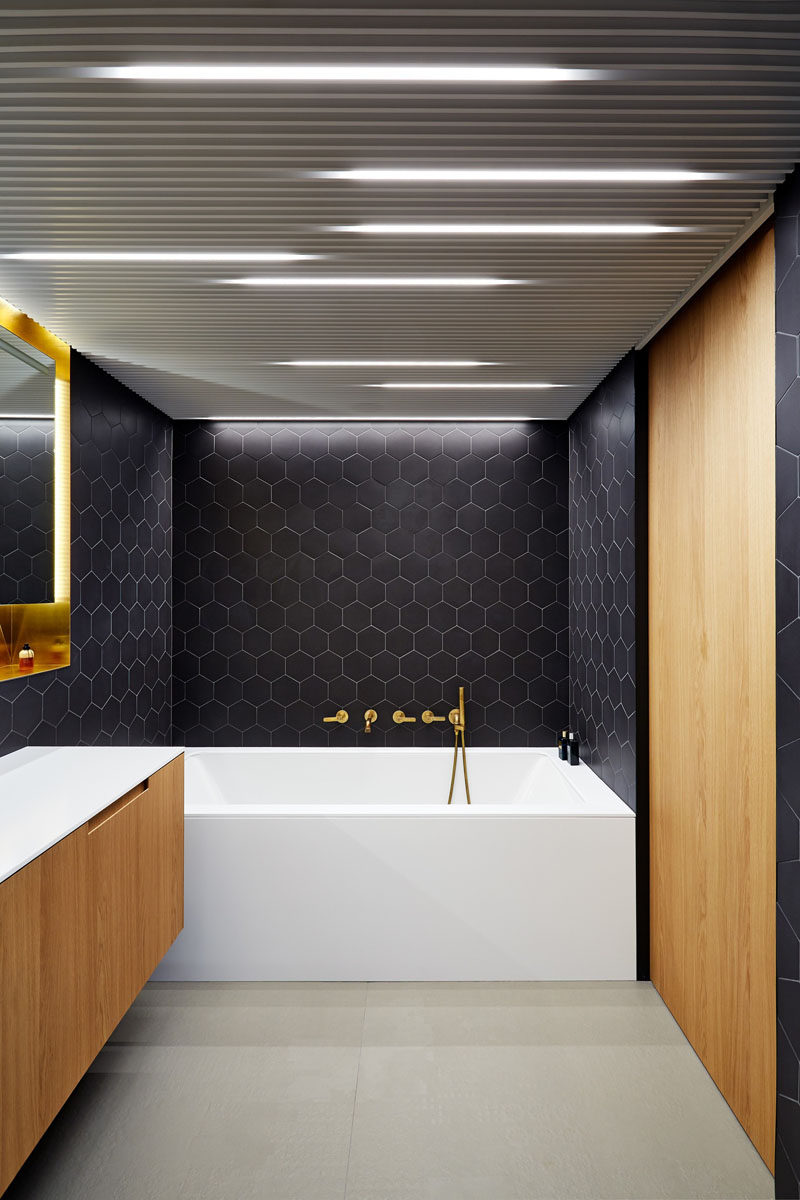 Bathroom Design Idea - Often black in bathrooms can make them feel dark and closed in, but in this Prague apartment architect Lenka Míková, combined black with brass, white and wood to give it a contemporary, luxurious feeling, perfect for a bathroom.