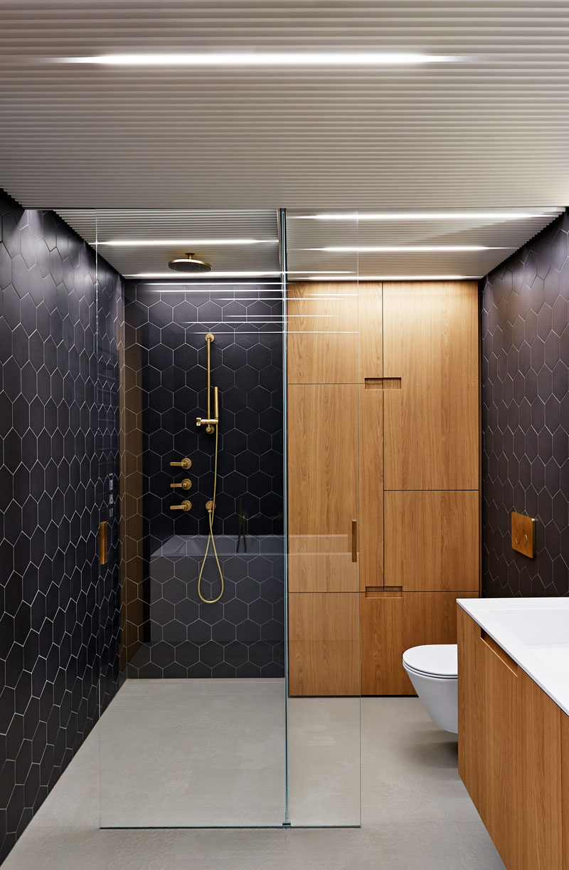 Bathroom Design Idea - Often black in bathrooms can make them feel dark and closed in, but in this Prague apartment architect Lenka Míková, combined black with brass, white and wood to give it a contemporary, luxurious feeling, perfect for a bathroom.