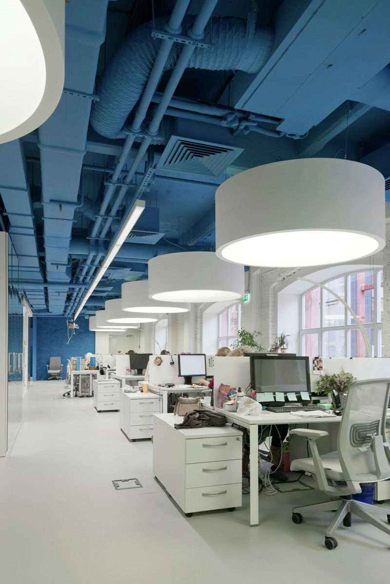 The saturated blue ceiling and wall surrounds bright whites in this media agency's office.