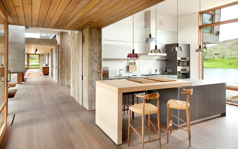 In this kitchen, pendant lights highlight the island that has a small dining space attached.