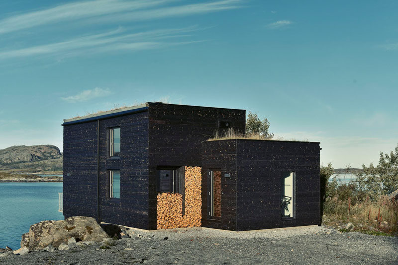 Charred wood siding and a green roof cover this small home on the coastline of Norway.