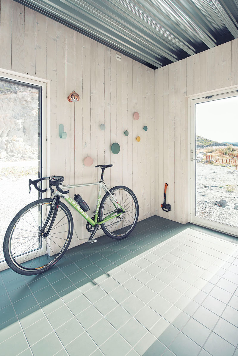 As you enter this small house, there's a tile entryway with walls lined with wood, that provides a space for storing a bike, coats and shoes.