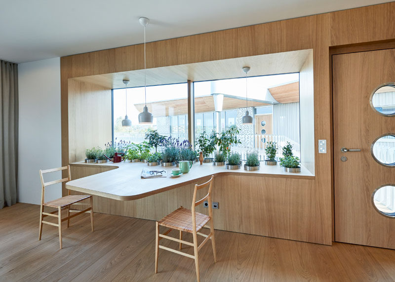 This window has a wide sill with lots of plants, that also extends and becomes a table for two.