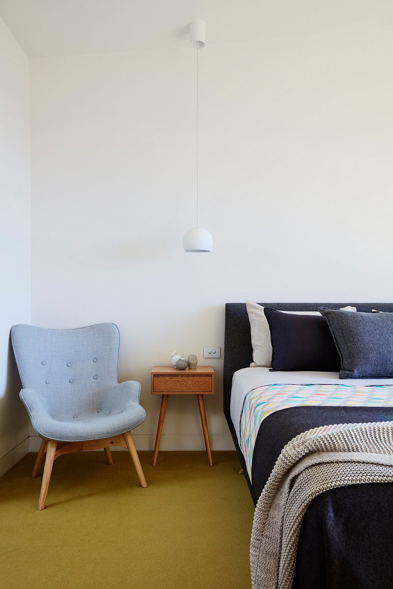 In this bedroom, bright carpet creates a sense of fun, and simple white pendant lights have been installed as bedside table lamps.