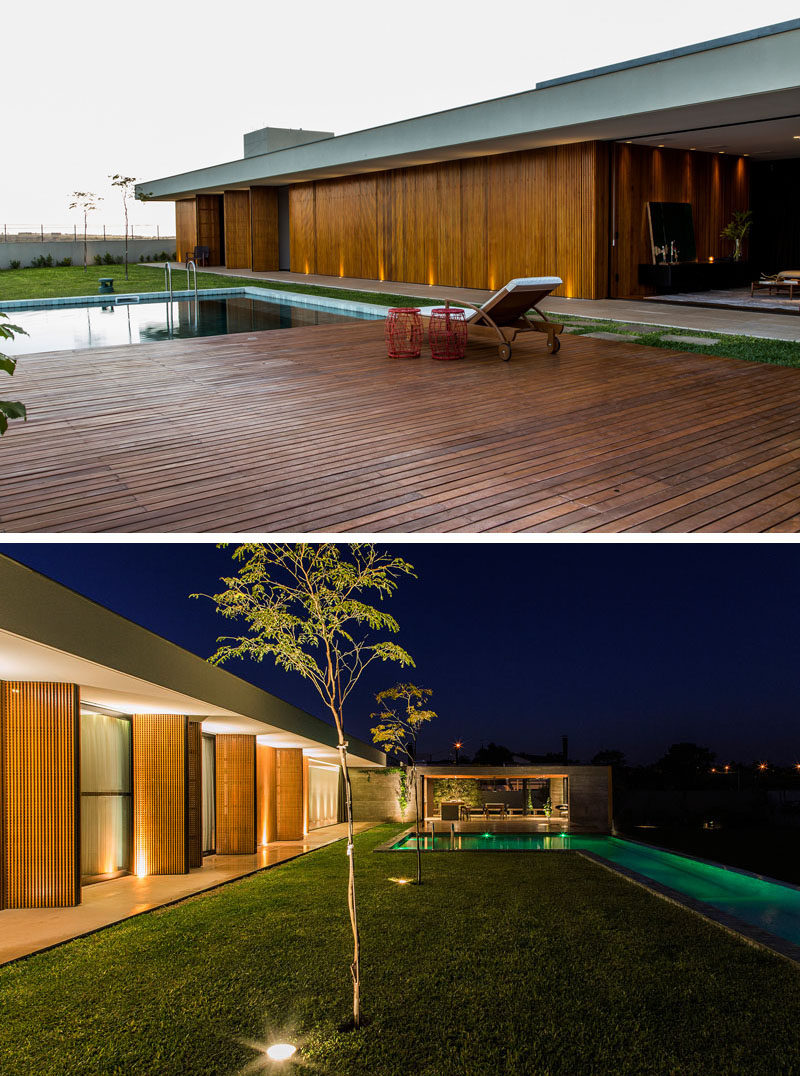 At night, the trees, swimming pool and exterior of this home are all lit up.