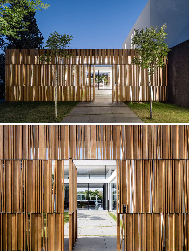 To enter this home, you walk down a tree lined path and through a wooden facade that partially blocks the view to the inside of the home.