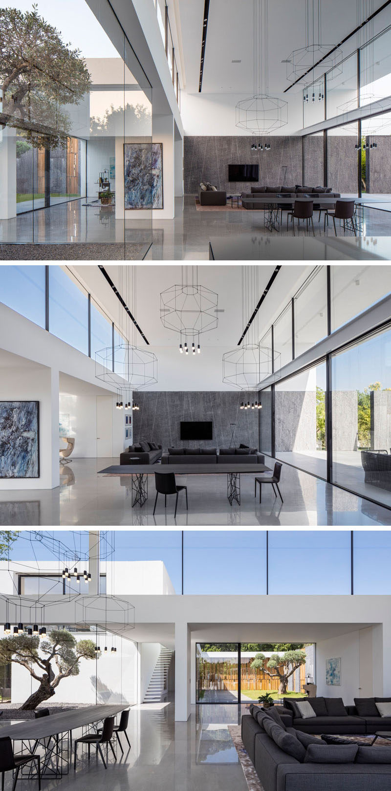 The living room, dining room and kitchen of this home, all share the same space that has a double-height ceiling and windows on either side. A large dark stone wall in the living area carries through to the outside of the home and the backyard.