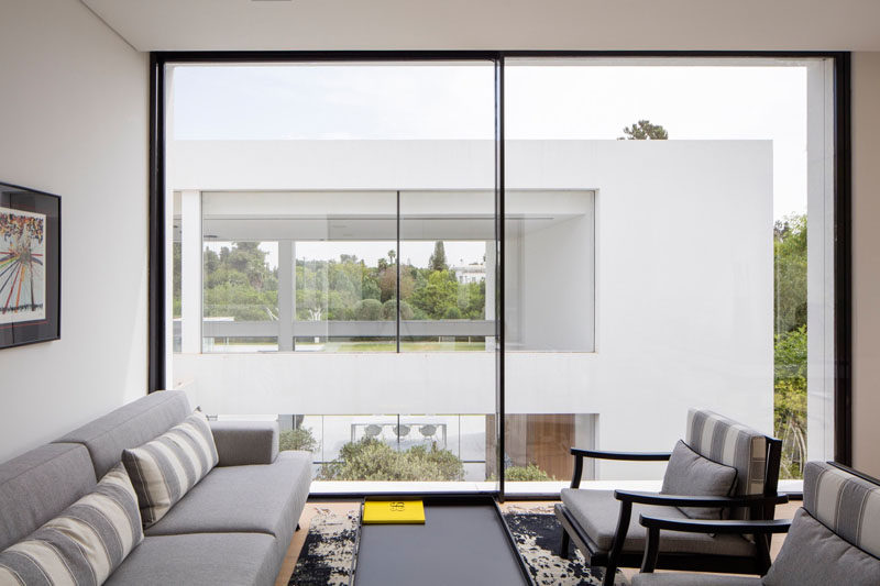 This sitting room has large windows that take up the entire wall and let an abundance of natural light into the room.