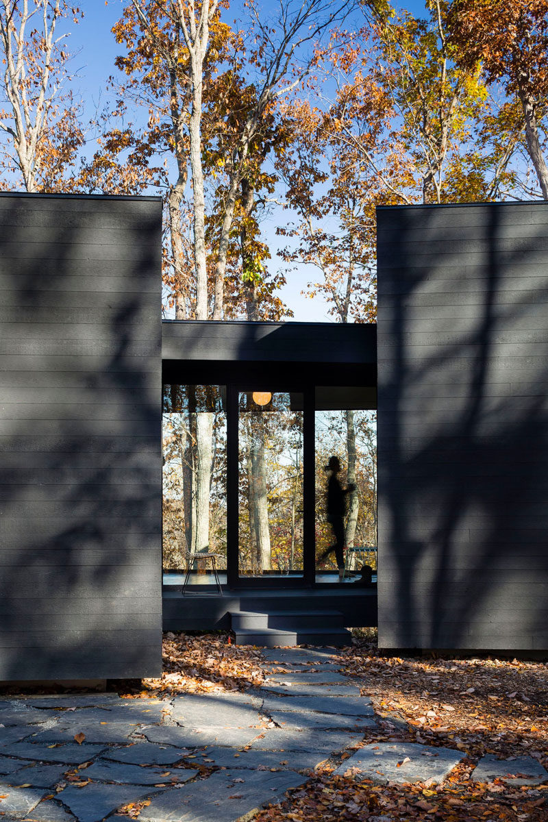 A stone pathway guides you to the entrance of this home in the forest.