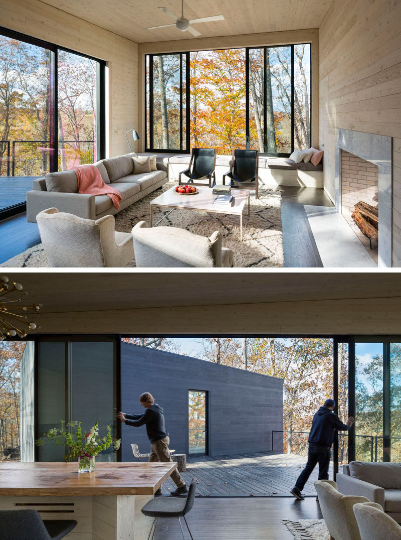 This living room has built-in bench seating under the window, and large doors with black frames can be slid open to provide access to the deck.