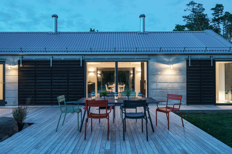 On one side of this home there's a wooden deck with room for an dining table.